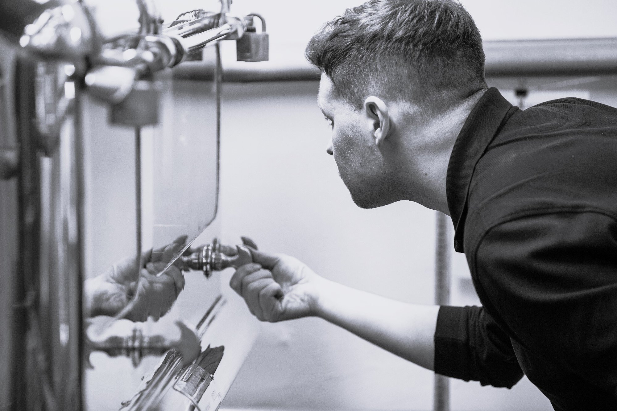 An image of our distiller checking the spirit safe to make Benromach Single Malt Scotch Whisky An image of our distiller checking the spirit safe to make Benromach Single Malt Scotch Whisky